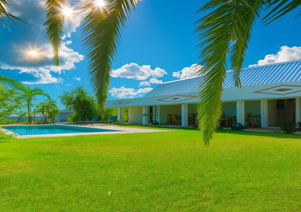 Pool and tropical garden in front of a villa in the sunshine