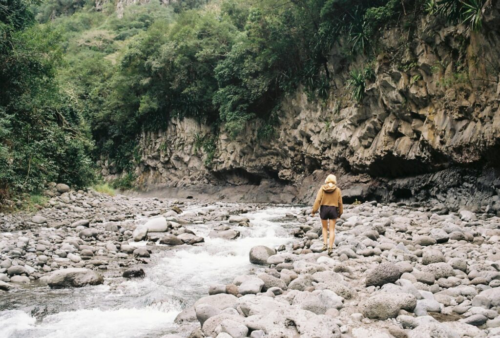 a person standing on rocks near a river
